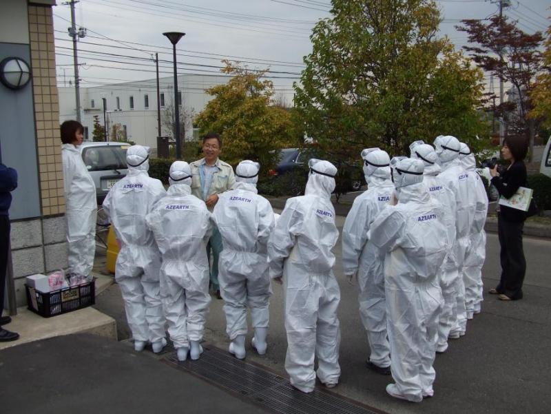 古川黎明中学校の生徒が防護服を着て説明を受けている様子