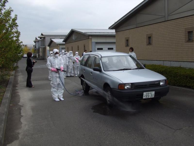 古川黎明中学校の生徒が防護服を着て消毒作業をしている様子