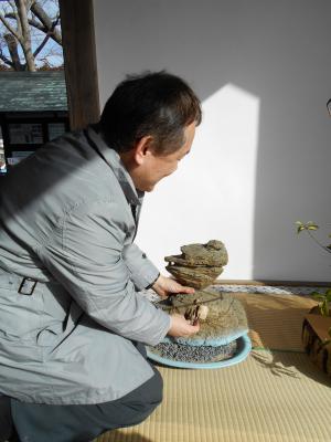 観瀾亭にある、石でつくられた仁王島の模型に触れている写真