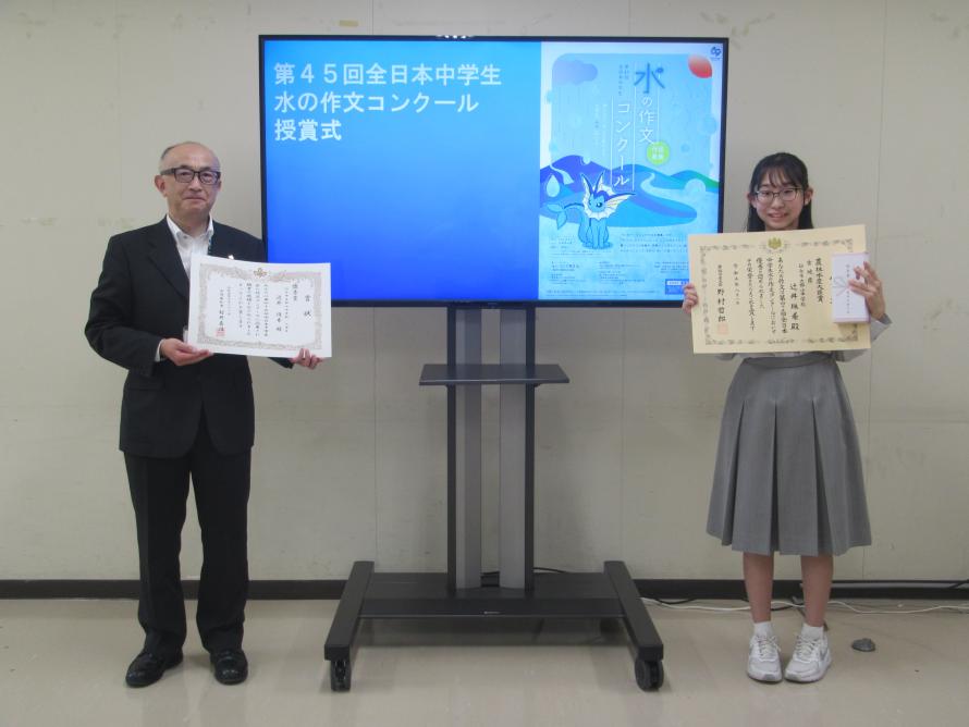 環境生活部長（左）と受賞者辻井珠希さん（右ととの記念写真