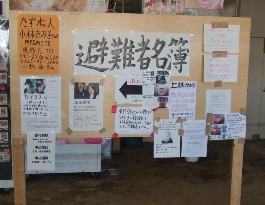 Handwritten memos posted at an evacuation center seeking individuals and a confirmation of their safety