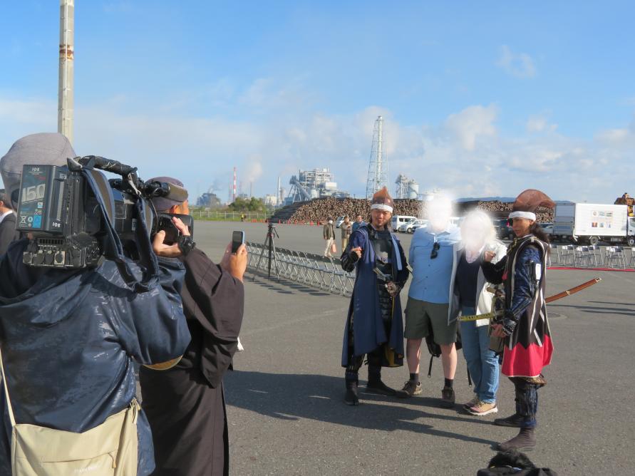 はい「ずんだ餅」のかけ声とともに伊達武将隊のメンバーと記念撮影をする乗客の方々