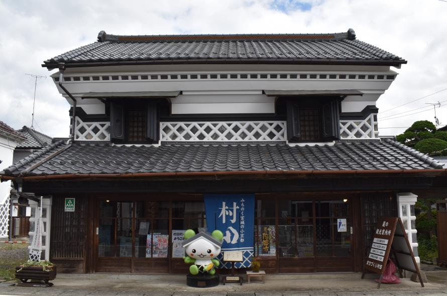 村田町の伝統的な蔵造りの建物を活用した「蔵の観光案内所」の外観とマスコットキャラクター